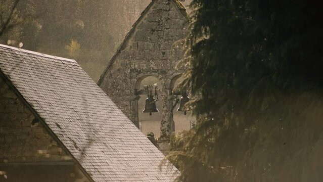 Old small church bells in sunny rain slow motion
