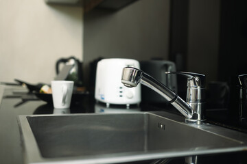 Stainless steel kitchen sink and tap water in modern kitchen - 792664940