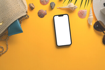 Smartphone with blank screen, sunglasses, straw hat and seashells on yellow background