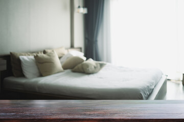 Empty wooden table top and blurred cozy bedroom interior. For your design content or product
