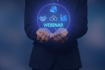 Webinar. Businessman holding virtual icons on color background, closeup