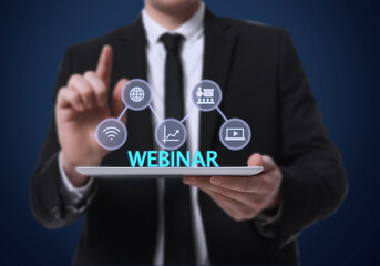 Webinar. Man holding tablet on dark blue background, closeup. Virtual screen with icons over computer