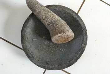 Close-up. The traditional tool, namely a mortar made of stone, is used to pound chili sauce and a...