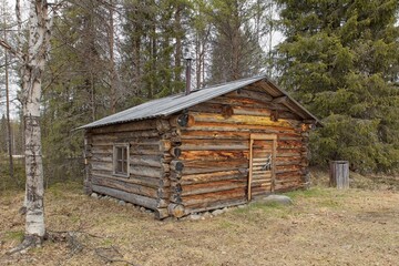 Old log cabin in cloudy spring weather at Riutukka Log Floating Museum, Salla, Lapland, Finland.