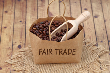 Papiertüte mit gerösteten Kaffeebohnen und Fairtrade-Beschriftung. - obrazy, fototapety, plakaty