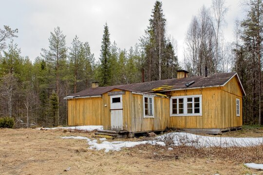 Old log lumberjack bunkhouse  in cloudy spring weather at Riutukka Log Floating Museum, Salla, Lapland, Finland.