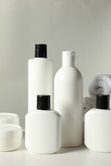 Different bath accessories on white table against grey background, closeup