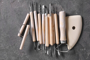 Set of different clay crafting tools on grey table, top view