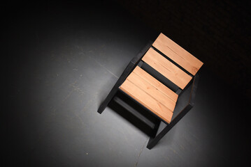 Iron loft style armchair on the black dark background. Front view.