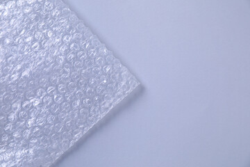 Transparent bubble wrap on gray background, top view. Space for text