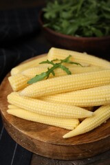 Tasty fresh yellow baby corns on wooden table, closeup