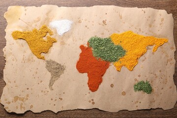 World map of different spices on wooden table, top view