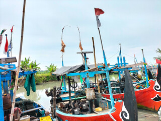Selective focus. Fishing boats are anchored at the mouth of a shallow river called Kali Biru,...
