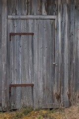 Locked weathered door on a wood building.