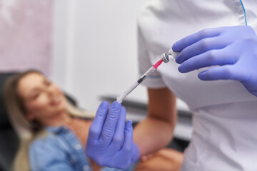 Doctor preparing syringe before beauty procedure