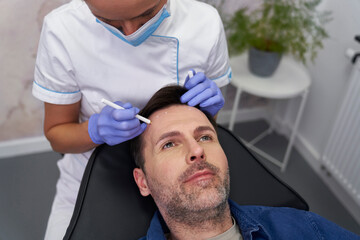 Man having facelifting procedure in beauty salon