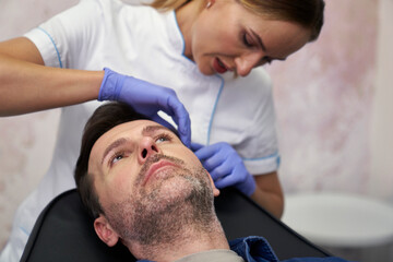 Man having facelifting procedure in beauty salon.