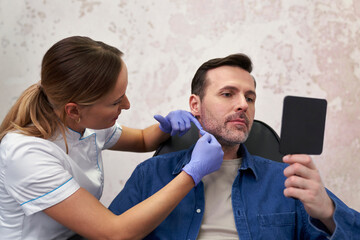 Doctor and patient before beauty procedure in beauty salon