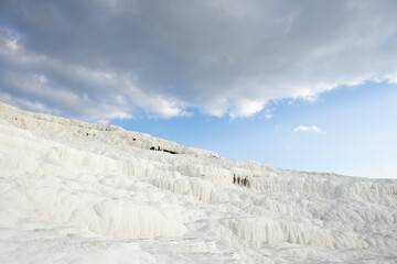 Dramatic clouds over the white terraces of Pamukkale in Denizli, Turkey, creating a striking...
