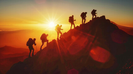 A group of hikers trekking up a mountain at sunset, silhouetted against the golden sky with the sun setting in the background