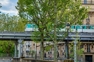 Fototapeta na wymiar Paris Metro Crossing Metal Bridge in Urban Neighborhood