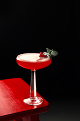 strawberry alcoholic cocktail. Red drink in a martini glass. Strawberry Martini garnished with a sprig of mint, strawberries and powdered sugar. Nightlife, party, bar, restaurant
