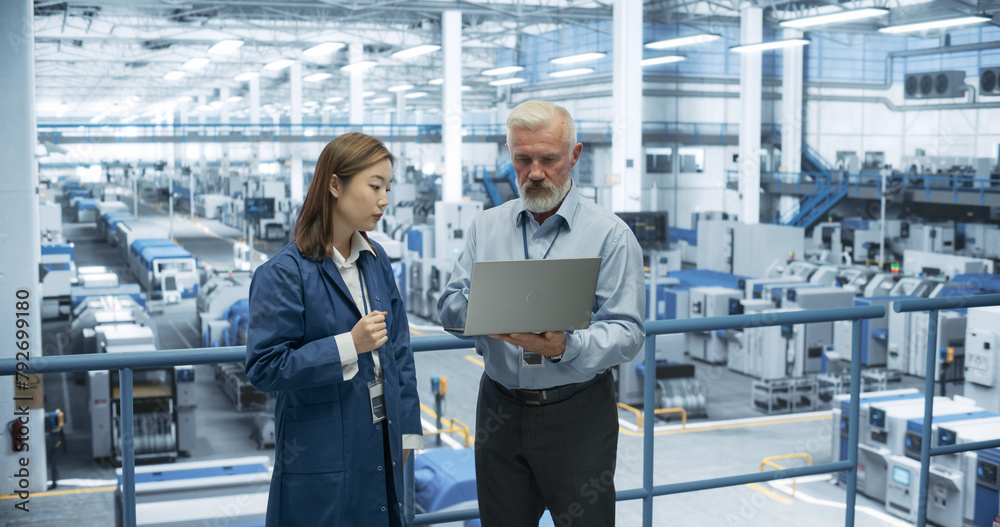 Poster industrial engineers working at a technology factory. caucasian man and japanese female using laptop
