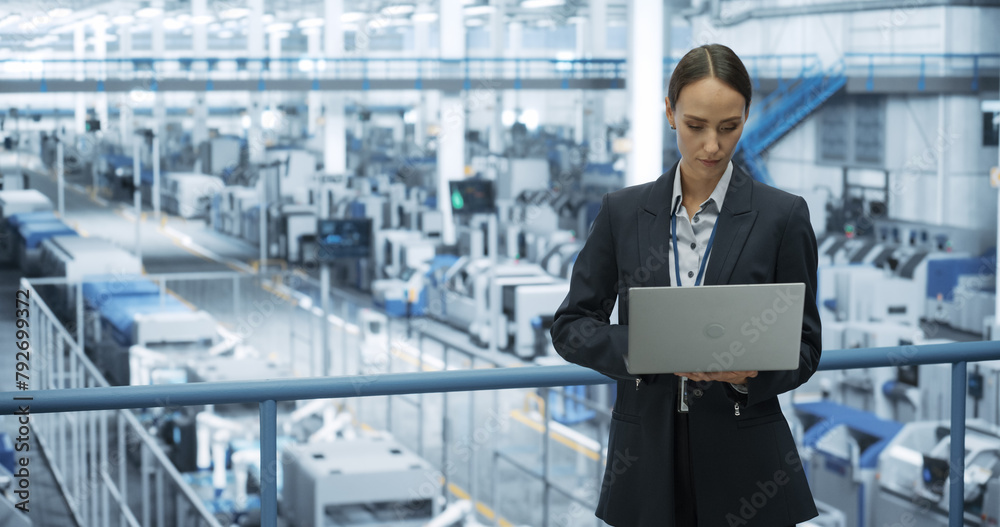 Poster Electronics Manufacturing Technician Working on a Laptop Computer at a Factory Space. Female Specialist Developing, Maintaining, Upgrading Programs for Machine Production and Assembly