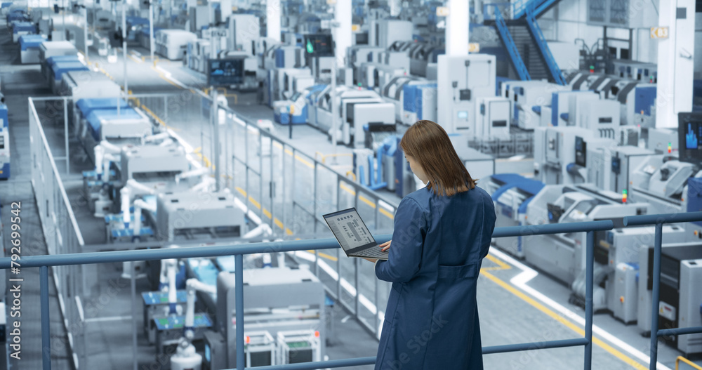 Aufkleber asian female engineer standing in a factory facility, working on laptop computer, researching and de