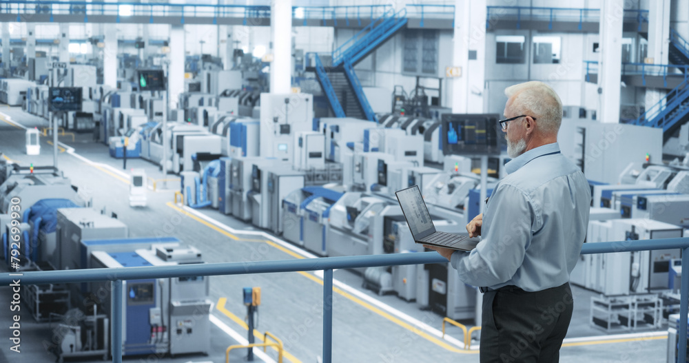 Poster Electronics Manufacturing Technician Working on a Laptop Computer at a Factory Space. Specialist Developing, Maintaining, Fine-Tuning Programs for Machine Production and Assembly