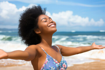 Portrait of a happy young african american woman on the beach wearing a blue floral dress.