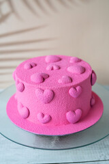 Beautiful cake with pink hearts on a beige background.