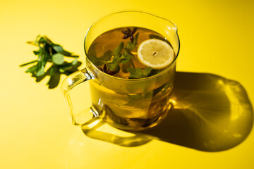 Green tea with lemon mint and star anise on a yellow background