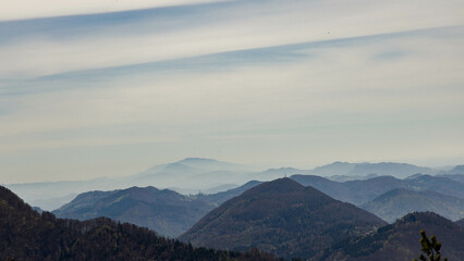 Foggy landscape in the early morning. Green mountains covered with thick fog