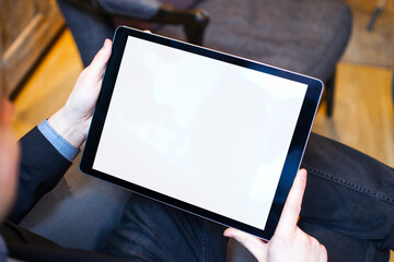 Hand holding tablet with blank screen