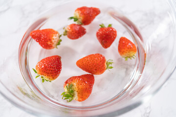Preparing Strawberries in a Glass Mixing Bowl with Water - 792725953