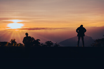 Silhouette of a person standing and admiring the scenery When the sun is rising On the viewpoint of...