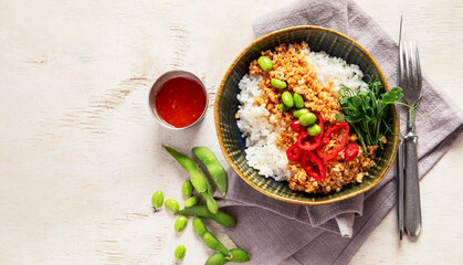 Vegan food. Soy meat, white rice, beans, red pepper on light wooden background