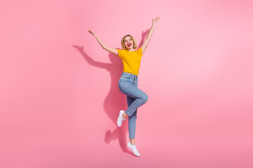 Full length photo of carefree funky lady dressed yellow t-shirt jumping high isolated pink color...