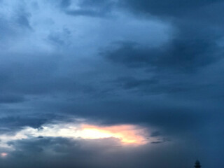 a dark sky with clouds and a bird flying in the sky