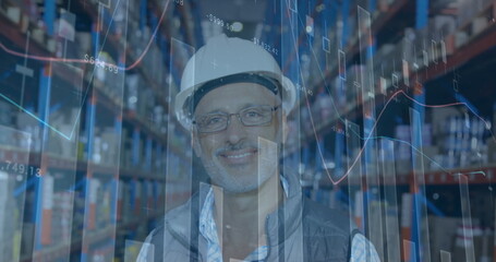 Image of financial graphs over happy caucasian male warehouse worker