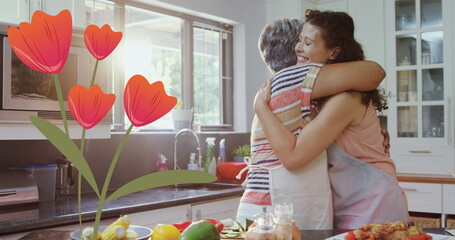 Image of flowers icon over happy biracial adult daughter embracing mother in kitchen - Powered by Adobe