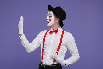 Mime artist making excited face on purple background