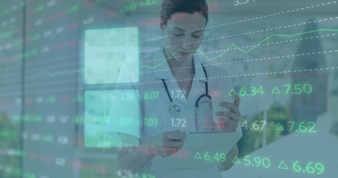 Fototapeta Image of financial data processing over caucasian female doctor at hospital