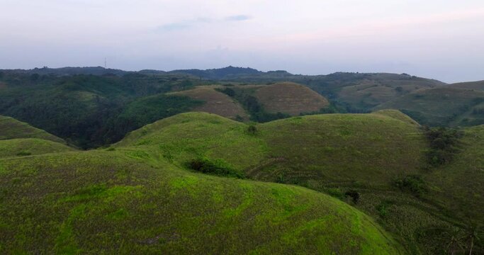 Bright Green Terrain Of Teletubbies Hill At Sunset On Nusa Penida Island In Bali, Indonesia. Aerial Shot