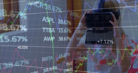 Image of financial data processing over caucasian woman using vr headset