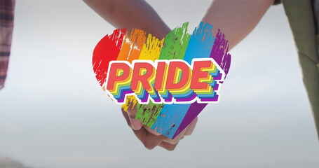 Image of rainbow heart and pride over hands of caucasian lesbian couple - obrazy, fototapety, plakaty
