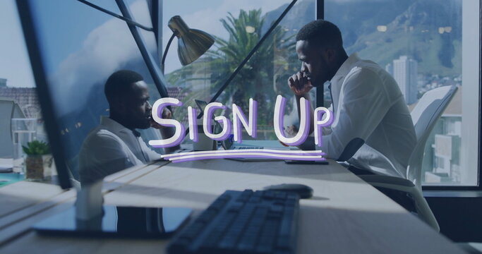 Image of sign up text over african american businessman using laptop in office