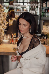 Woman Sitting at Bar With Glass of Wine, Relaxing and Enjoying Her Evening Out