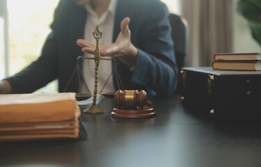 Fototapeta na wymiar Justice and Law concept. Legal counsel presents to the client a signed contract with gavel and legal law or legal having team meeting at law firm in background